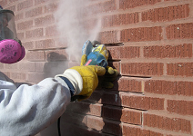 Chimney Technician using a grinder to remove mortar between chimney bricks